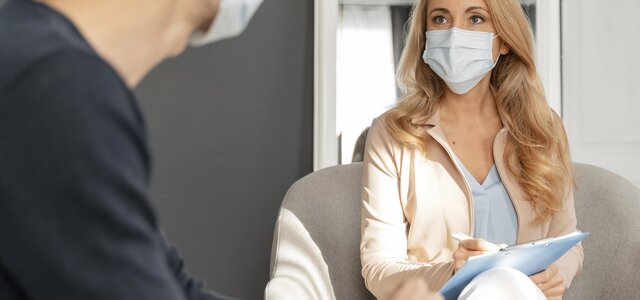 man_with_mask_talking_to_woman_counselor