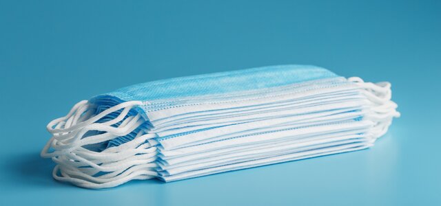 stack_of_protective_medical_masks_on_a_blue_table_isolate_protection_against_diseases_viruses_and...