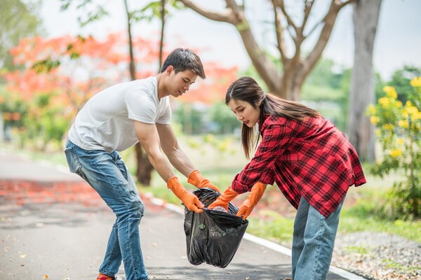 men_and_women_help_each_other_to_collect_garbage