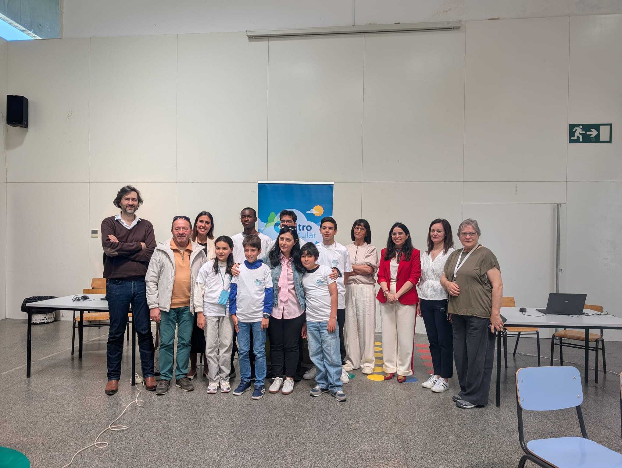 Grupo de alunos, cerca de seis, numa sala de aula, com professores e representantes das entidades...